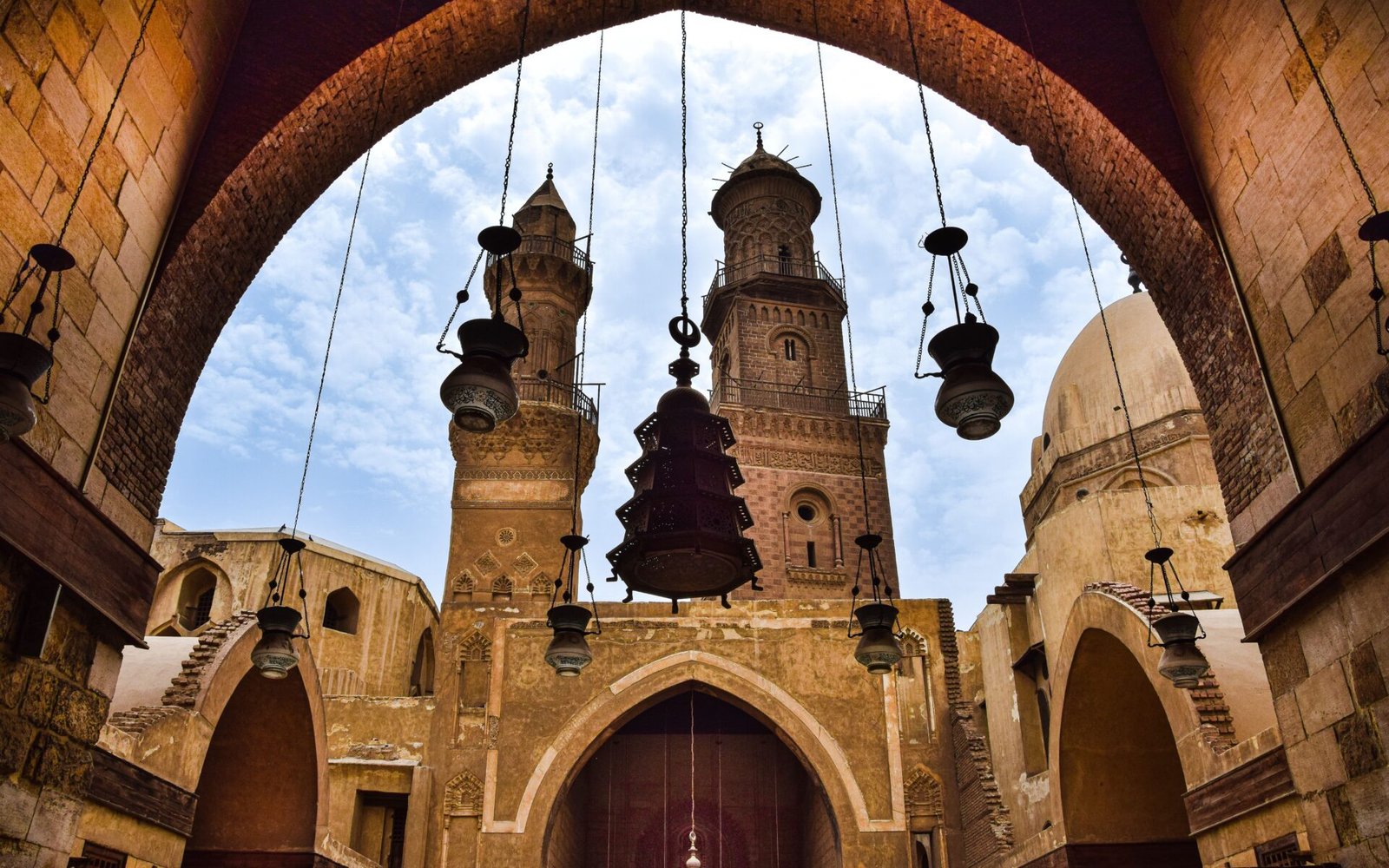Majestic Islamic architecture with arches and towers at Qalawun Complex, Cairo.