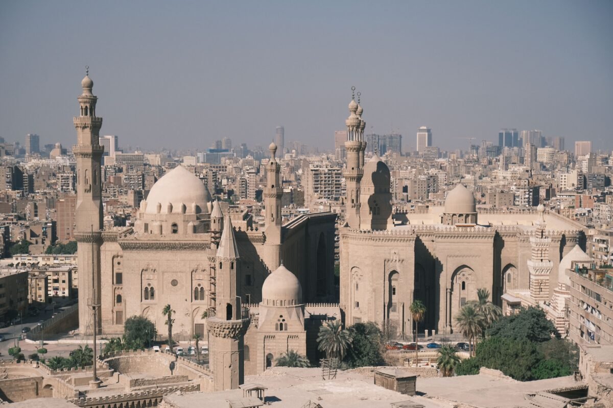 Scenic aerial view of Cairo with the iconic Mosque-Madrassa of Sultan Hassan and city skyline.